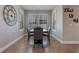 Charming dining room featuring a dark table, four chairs, a large wall clock, and three windows with shutters at 15443 Sugarcup Ct, Orlando, FL 32828