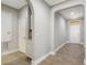 Hallway features tiled flooring, white trim, an arched entryway and a white door at the end at 15443 Sugarcup Ct, Orlando, FL 32828