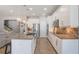 Modern kitchen with white cabinets, stainless steel appliances, a large island, and stylish pendant lighting at 15443 Sugarcup Ct, Orlando, FL 32828