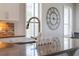 Farmhouse sink in a modern kitchen with quartz countertops, decorative elements and stainless steel appliances at 15443 Sugarcup Ct, Orlando, FL 32828