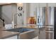 Modern kitchen island features a stainless steel sink and large refrigerator with decorative lighting and hexagon wall art at 15443 Sugarcup Ct, Orlando, FL 32828