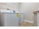 A laundry room features a white washer and dryer next to a cabinet at 15443 Sugarcup Ct, Orlando, FL 32828