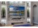 Living room features an entertainment center with stone accents, decorative shelving and a large-screen television at 15443 Sugarcup Ct, Orlando, FL 32828