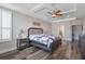 Main bedroom with tray ceiling, fan, shutters, and ensuite bathroom at 15443 Sugarcup Ct, Orlando, FL 32828