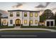 Stunning two-story home featuring a black tile roof, white stucco, arched front door, and manicured landscaping at 185 Sylvan Blvd, Winter Park, FL 32789
