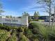 A welcoming entrance sign to Trinity Lakes Amenity Center with lush landscaping and blue skies at 1880 Perch Hammock Loop, Groveland, FL 34736