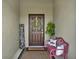 Inviting front porch with a decorative wreath, charming bench, and a welcoming atmosphere at 1880 Perch Hammock Loop, Groveland, FL 34736