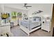Bright primary bedroom with a ceiling fan, large windows, and stylish decor at 1880 Perch Hammock Loop, Groveland, FL 34736