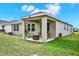 Covered patio with seating area overlooks the backyard, great for outdoor entertaining at 1880 Perch Hammock Loop, Groveland, FL 34736