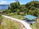 Aerial shot of a picnic shelter with tables and grills, surrounded by lush greenery and a view of the lake at 1880 Perch Hammock Loop, Groveland, FL 34736