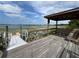 View of a wooden pier with covered seating area overlooking a serene lake with lily pads at 1880 Perch Hammock Loop, Groveland, FL 34736