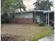 Single-story home featuring a carport, neutral color palette, brick accents, and a spacious front yard at 1909 Edwin Blvd, Winter Park, FL 32792