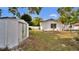 A storage shed sits in the backyard of this home, surrounded by a lawn and a white picket fence at 1965 Greenview Dr, Deltona, FL 32725