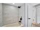 Modern bathroom with tiled walls, bathtub, shower head, and updated fixtures at 1965 Greenview Dr, Deltona, FL 32725