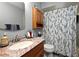 Bathroom features a vanity with a stone countertop and a shower/tub with a blue and white floral shower curtain at 2102 Urbana Ave, Deltona, FL 32725