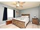 This cozy bedroom features light blue walls, a ceiling fan, and a comfortable wooden bed frame at 2102 Urbana Ave, Deltona, FL 32725