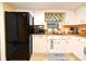 Functional kitchen featuring white cabinets, black appliances, and a convenient layout for easy cooking at 2102 Urbana Ave, Deltona, FL 32725
