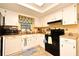 Efficient kitchen with white cabinetry, black appliances, and a sunny window that brings in lots of light at 2102 Urbana Ave, Deltona, FL 32725