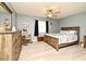 Serene main bedroom with a ceiling fan, wooden furniture, and calm blue walls, ready for relaxation at 2102 Urbana Ave, Deltona, FL 32725