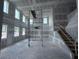 Unfinished living room featuring drywall, large windows, scaffold and a staircase at 22113 Amberbush Ct., Mount Dora, FL 32757