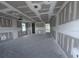 Unfinished living room featuring bare concrete floors, drywall and multiple windows at 22113 Amberbush Ct., Mount Dora, FL 32757