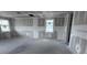 Unfinished living room featuring bare concrete floors, drywall and large windows at 22113 Amberbush Ct., Mount Dora, FL 32757