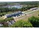 Stunning aerial view of newly built townhomes with garage parking near a tranquil lake and lush green surroundings at 222 Glass Onion Dr, Groveland, FL 34737