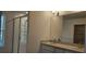 Bright bathroom featuring a glass shower, double sinks, and a large mirror at 222 Glass Onion Dr, Groveland, FL 34737