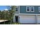 Charming two-story townhome featuring a two-car garage and a mix of gray and blue siding at 222 Glass Onion Dr, Groveland, FL 34737