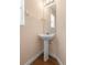 Bright half bathroom features a pedestal sink, mirror and lighting at 232 Oxford Rd, Davenport, FL 33896
