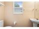 Bathroom with a window view, toilet and a pedestal sink at 232 Oxford Rd, Davenport, FL 33896