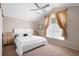 Bedroom boasts a ceiling fan, large window, and decoratively-chested nightstands flanking a white bed at 232 Oxford Rd, Davenport, FL 33896