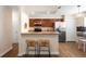 Open concept kitchen with stainless appliances, breakfast bar, and woven bar stools, with adjacent dining area at 232 Oxford Rd, Davenport, FL 33896
