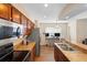 Modern kitchen with stainless steel appliances, double sink, wood cabinets, and breakfast bar at 232 Oxford Rd, Davenport, FL 33896