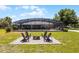 Backyard features a screened pool area and fire pit with seating, perfect for outdoor entertaining at 23203 Outback Ln, Eustis, FL 32736