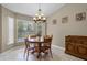 Dining area with round table, chandelier lighting, and large window with natural light at 23203 Outback Ln, Eustis, FL 32736