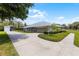 Ranch home featuring a circular driveway, well-manicured landscaping, and a spacious layout with a boat storage building at 23203 Outback Ln, Eustis, FL 32736