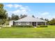 Charming single-story home featuring a covered porch, well-manicured lawn, and a detached garage, perfect for country living at 23203 Outback Ln, Eustis, FL 32736