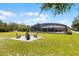 Backyard fire pit with outdoor chairs, a serene space with a pool enclosure in a well-maintained yard at 23203 Outback Ln, Eustis, FL 32736