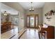 Inviting foyer with tile floors, grand entrance door, and chandelier lighting at 23203 Outback Ln, Eustis, FL 32736