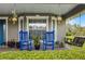 Cozy front porch with comfortable blue rocking chairs and a charming swing at 23203 Outback Ln, Eustis, FL 32736