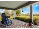 Relaxing covered front porch with swing, rocking chair, and a view of the yard at 23203 Outback Ln, Eustis, FL 32736
