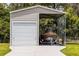 Large open metal garage with a rolling door and a boat with covering inside at 23203 Outback Ln, Eustis, FL 32736