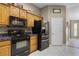 Kitchen featuring black appliances, light wood cabinetry, and neutral color palette at 23203 Outback Ln, Eustis, FL 32736