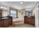 Large bathroom with double sinks, granite counters, tiled floors, and a soaking tub at 23203 Outback Ln, Eustis, FL 32736