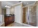 Bathroom featuring double sinks, granite counters, glass shower and tile floors at 23203 Outback Ln, Eustis, FL 32736