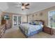 Spacious bedroom with tray ceiling, ceiling fan, French doors, and neutral color palette at 23203 Outback Ln, Eustis, FL 32736