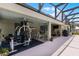 Rear covered patio with exercise equipment, dining set, and access to the screened pool area at 23203 Outback Ln, Eustis, FL 32736