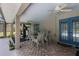 Covered patio with dining set and access to the screened pool area with exercise equipment at 23203 Outback Ln, Eustis, FL 32736