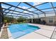 Screened pool with water feature, lush landscaping, outdoor seating, and spacious patio at 23203 Outback Ln, Eustis, FL 32736